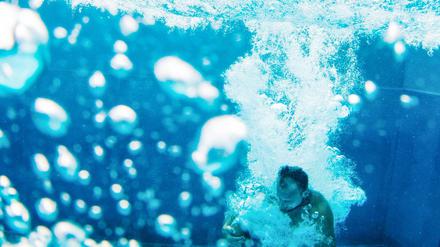 Ein Schwimmer springt in das Schwimmbecken des Rheinbads.