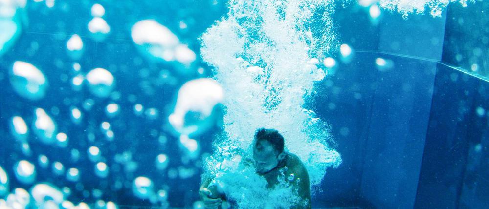 Ein Schwimmer springt in das Schwimmbecken des Rheinbads.