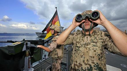 Deutsche Marine-Soldaten halten 2008 an Bord der Fregatte "Karlsruhe" an einem Maschinengewehr Wache.