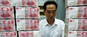 Ein chinesischer Bankangestellter zählt Geldscheine 