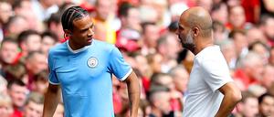 Manchesters Leroy Sane (l) spricht nach seiner Auswechslung mit Trainer Pep Guardiola. 