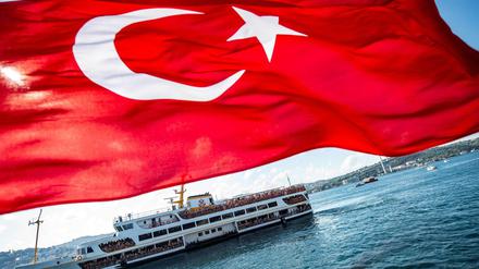 Ein Fährboot über den Bosporus bei Istanbul. Im Vordergrund weht die türkische Flagge (Symbolbild).