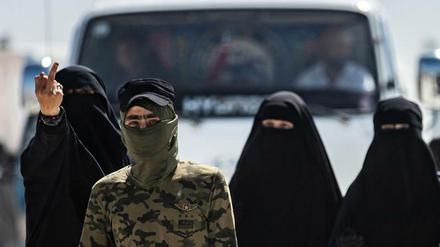 Ein Wachmann der kurdisch-assyrisch-arabischen Verwaltung in Nordsyrien führt IS-Frauen durch ein Gefangenencamp.