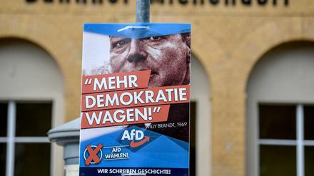 Ein Plakat mit einem Bild des SPD-Politikers Willy Brandt - und der Aufschrift "Mehr Demokratie wagen" der AfD hängt am Bahnhof von Michendorf.