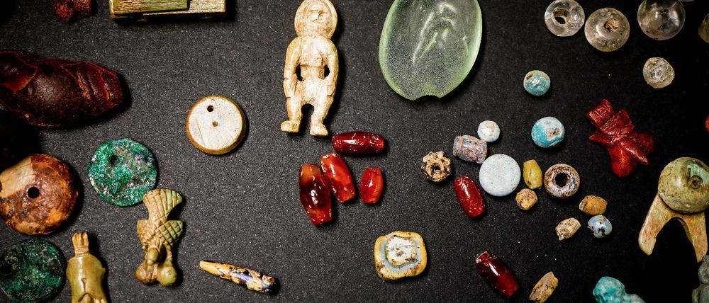 Amulette, Edelsteine und dekorative Elemente in Fayence, Bronze, Knochen und Bernstein, die in einer Truhe in der Ausgrabungsstätte im "Haus des Giardino" gefunden wurden.