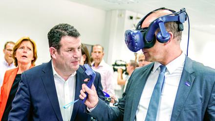 Arbeitsminister Hubertus Heil (SPD) lässt sich bei BASF von Vorstandschef Martin Brudermüller eine Virtual-Realität-Brille erklären