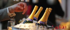 Ein Mann greift zu einer Champagner-Flasche. 
