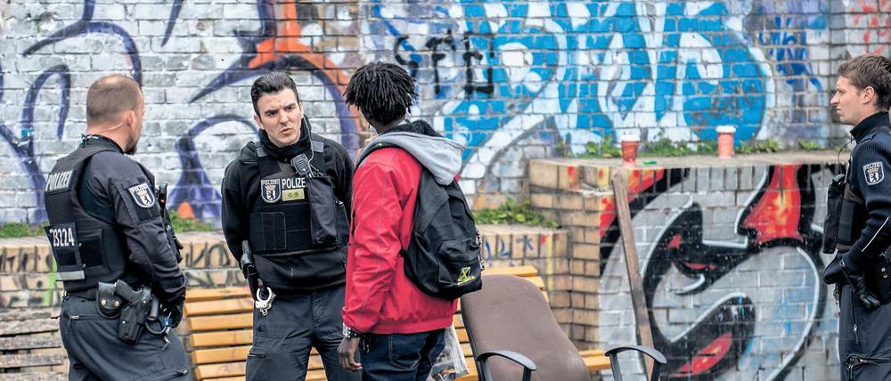 Polizisten kontrollieren im Görlitzer Park einen Mann.