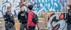 Polizisten kontrollieren im Görlitzer Park einen Mann.