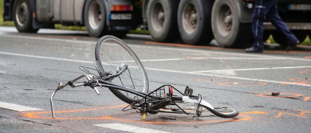 Nach einem Unfall liegt ein zerstörtes Fahrrad auf der Straße.