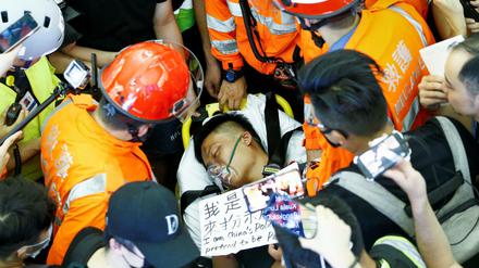 Einer der von Demonstranten angegriffenen Männern am Hongkonger Flughafen wird versorgt.