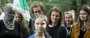 Greta Thunberg steht mit Aktivisten im Hambacher Forst, eine ist vermummt.