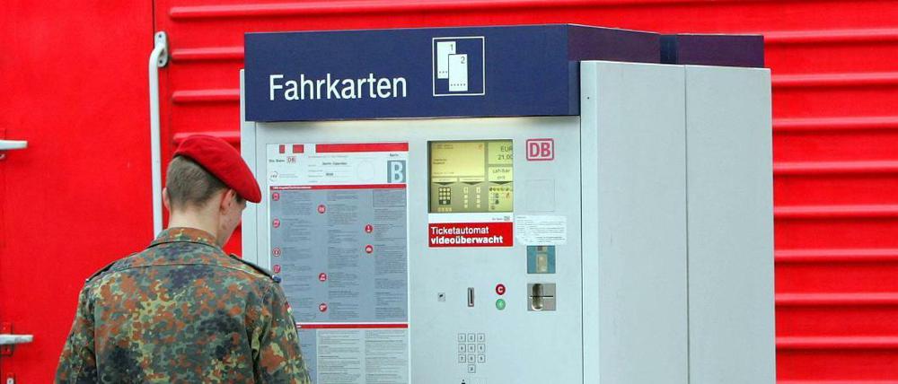 Soldat steht an einem Fahrkartenautomat 