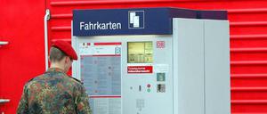 Soldat steht an einem Fahrkartenautomat 