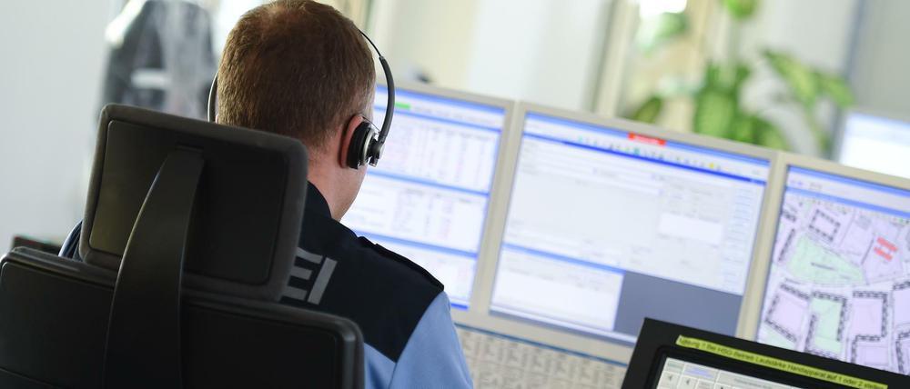 Polizist in der Einsatzzentrale vor Monitoren.