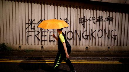 Ein Mann mit Regenschirm läuft in Hongkong. 