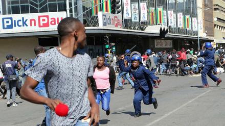 Bereitschaftspolizisten gehen in Harare gewaltsam gegen Demonstranten vor.