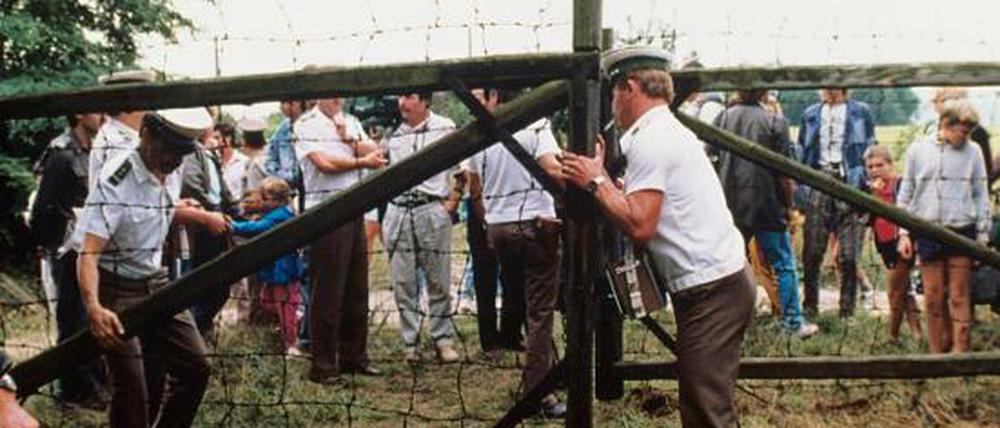 Ein Österreichischer Grenzer öffnet während des Picknicks ein Grenztor (Aufnahme vom 19. August 1989).