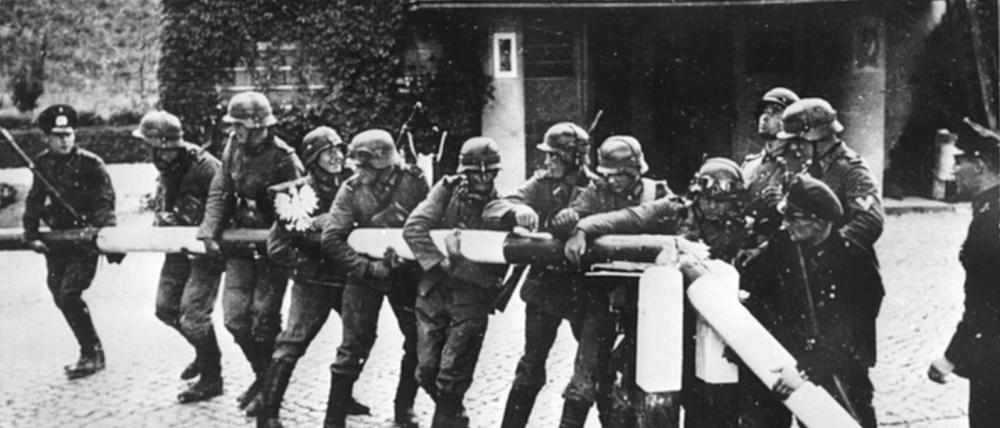 Beim Einmarsch deutscher Truppen in Polen am 01.09.1939 reißen Soldaten der deutschen Wehrmacht einen rot-weißen Schlagbaum an der deutsch-polnischen Grenze nieder.