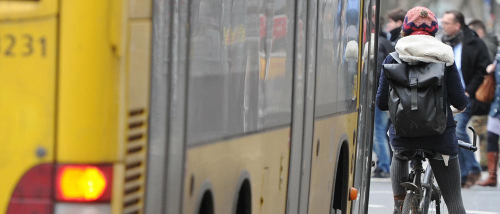 Ein Radfahrer steht auf einer Busspur an einer Kreuzung, hinter ihm ein Bus der BVG