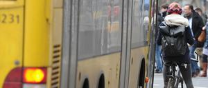 Ein Radfahrer steht auf einer Busspur an einer Kreuzung, hinter ihm ein Bus der BVG