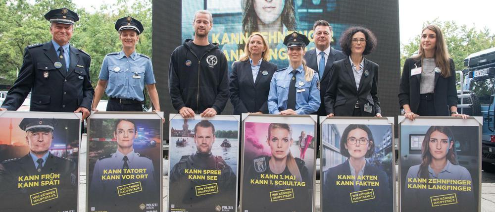 Die auf der neuen Imagekampagne der Berliner Polizei abgebildeten Polizisten halten ihre jeweiligen Plakate in den Händen.