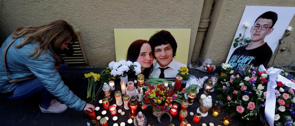 Eine Frau kniet am ersten Jahrestag des Verbrechens im Februar 2019 neben einer Gedenkstätte nieder. 