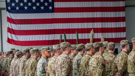 US-Soldaten stehen in den Storck-Barracks in Bayern vor einer Flagge der Vereinigten Staaten von Amerika.