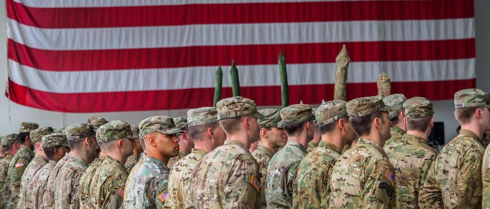 US-Soldaten stehen in den Storck-Barracks in Bayern vor einer Flagge der Vereinigten Staaten von Amerika.