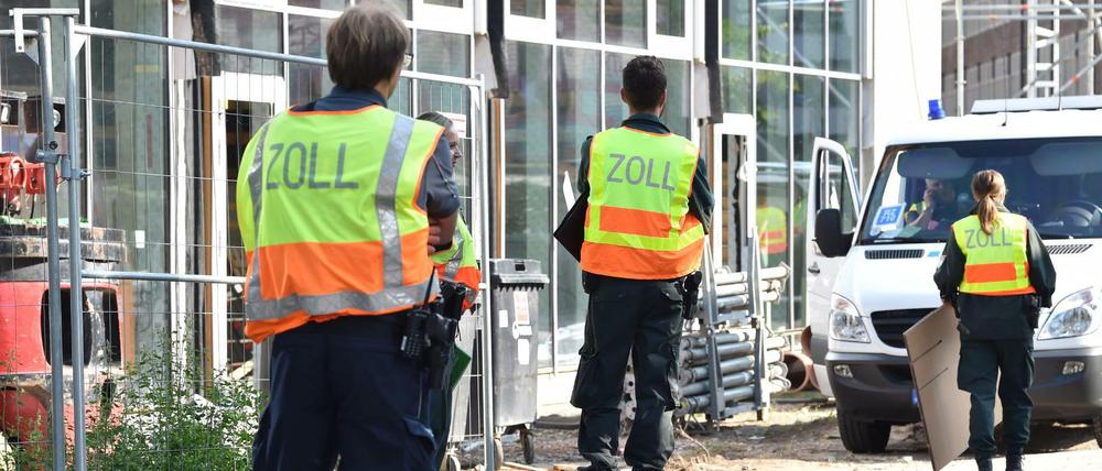 Zollbeamte stehen vor einer Baustelle im Berliner Stadtteil Stralau.