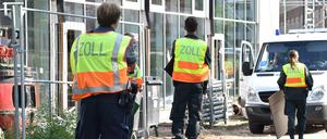 Zollbeamte stehen vor einer Baustelle im Berliner Stadtteil Stralau.