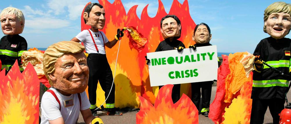 Demonstranten tragen Masken der G-7-Teilnehmer.