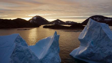 Eisberge treiben bei Sonnenaufgang in der Nähe von Kulusuk auf dem Wasser. 