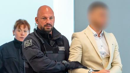 Alaa S. kommt mit Justizbeamten in den Gerichtssaal in Dresden. 