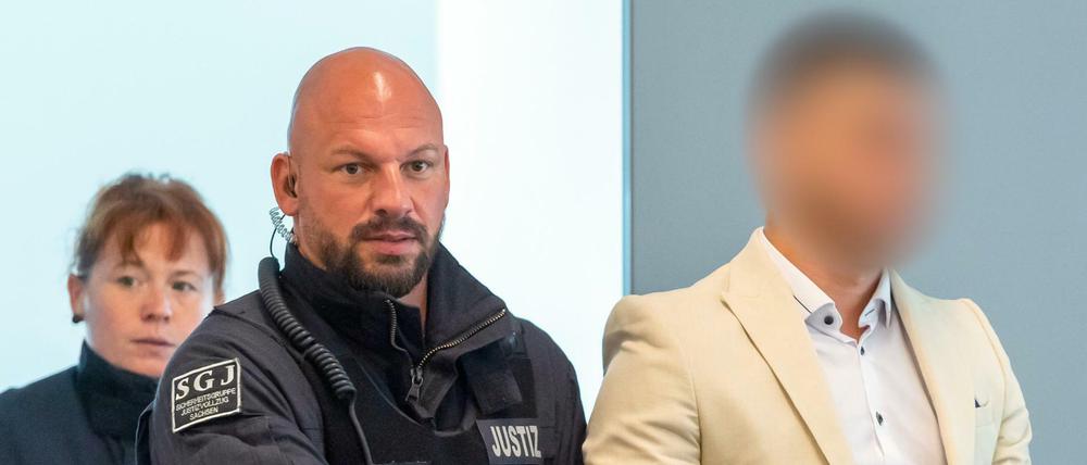 Alaa S. kommt mit Justizbeamten in den Gerichtssaal in Dresden.