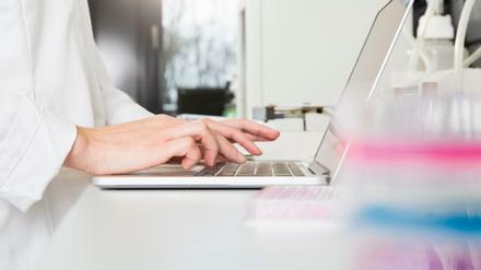 Eine Wissenschaftlerin tippt etwas in ihren Laptop ein.