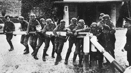 Deutsche reißen einen rot-weißen Schlagbaum an der deutsch-polnischen Grenze nieder. 