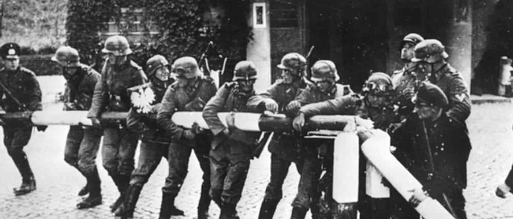Deutsche reißen einen rot-weißen Schlagbaum an der deutsch-polnischen Grenze nieder.