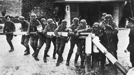 Soldaten der Wehrmacht reißen am 1. September 1939 einen Schlagbaum an der Grenze zu Polen nieder. 