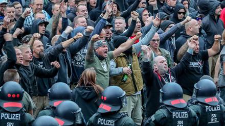  27.08.2018, Sachsen, Chemnitz: Demonstranten aus der rechten Szene gestikulieren und drohen Gegendemonstranten Gewalt an. 