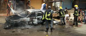 Afghanische Feuerwerkräfte löschen einen Brand an einem Auto nach einer Explosion.
