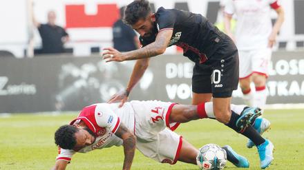 Ein Bild mit Symbolwert. Düsseldorfs Lewis Baker (am Boden) im Duell mit dem Leverkusener Kerem Demirbay. 
