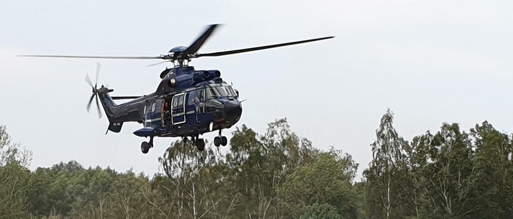 Ein Hubschrauber nimmt Wasser zum Löschen auf. In Brandenburg sind erneut Brände auf ehemaligen Truppenübungsplätzen ausgebrochen.