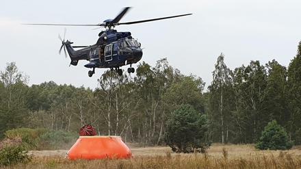 Ein Hubschrauber nimmt Wasser zum Löschen auf. Von den Bränden sind die ehemaligen Truppenübungsplätze Lehnin und Jüterbog betroffen.