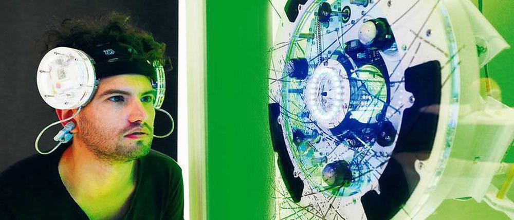 Gedankenbilder. Chris Walter sitzt im Futurium vor seiner Installation „Brainwaves“.