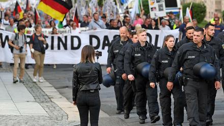Unterstützer der rechtsextremistischen Bewegung Pro Chemnitz laufen begleitet von Polizisten durch das Zentrum von Chemnitz.