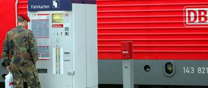 Soldat steht an einem Fahrkartenautomat am Bahnhof Berlin-Spandau.