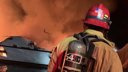 Ein Feuerwehrmann versucht, das vor der kalifornischen Küste in Brand geratene Schiff zu löschen.