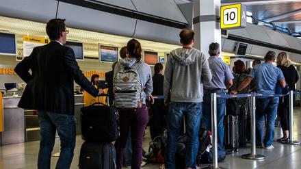 Reisende an einem Check-in-Schalter auf dem Flughafen Tegel.