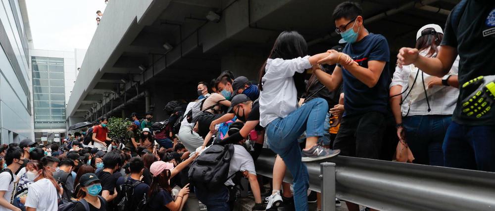 Prodemokratische Demonstranten verlassen den Flughafen wieder, nachdem dort Bereitschaftspolizisten eingetroffen sind.